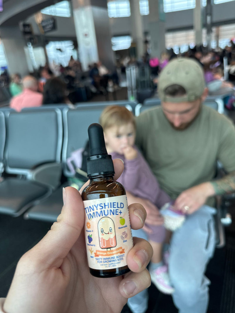 Mom giving TinyShield drops to child